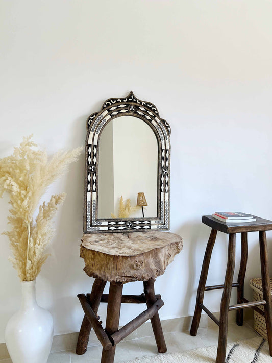 a mirror sitting on top of a wooden table