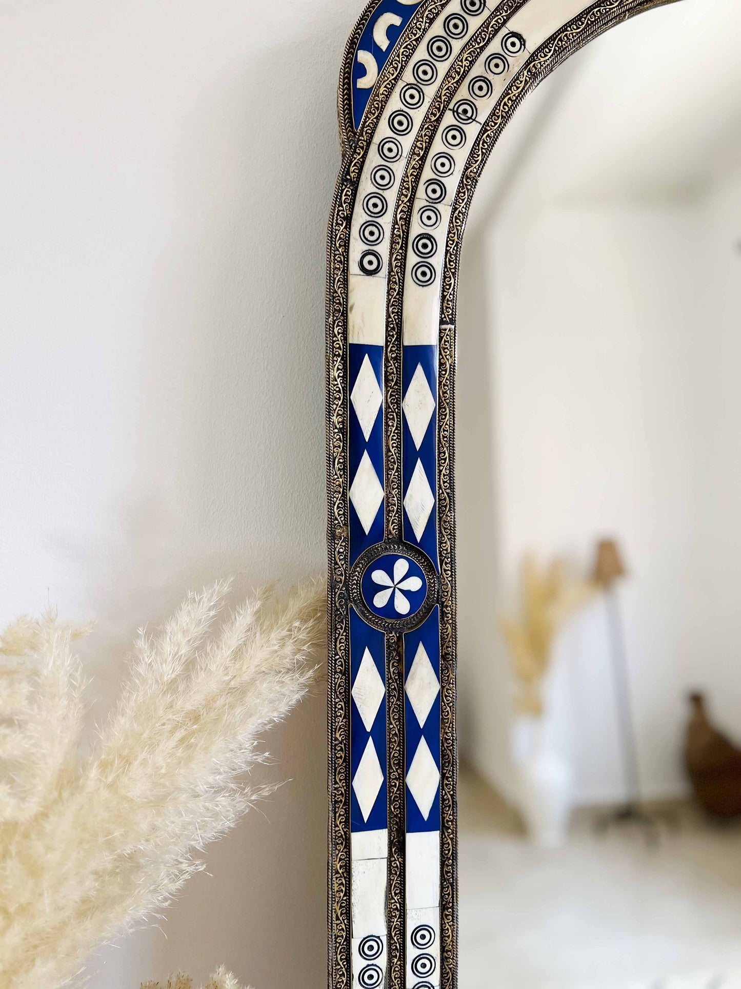 a blue and white mirror sitting on top of a wall