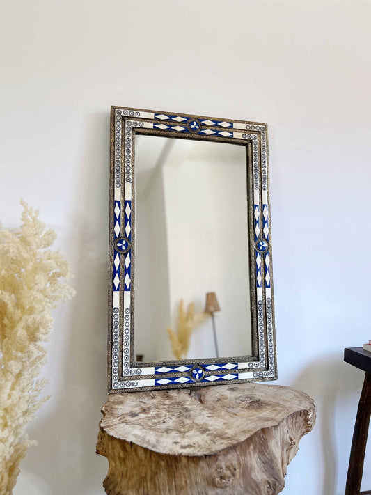 a mirror sitting on top of a wooden table