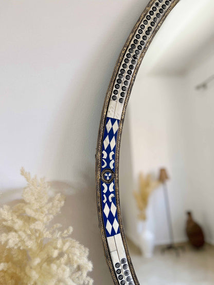 a blue and white mirror sitting on top of a wall