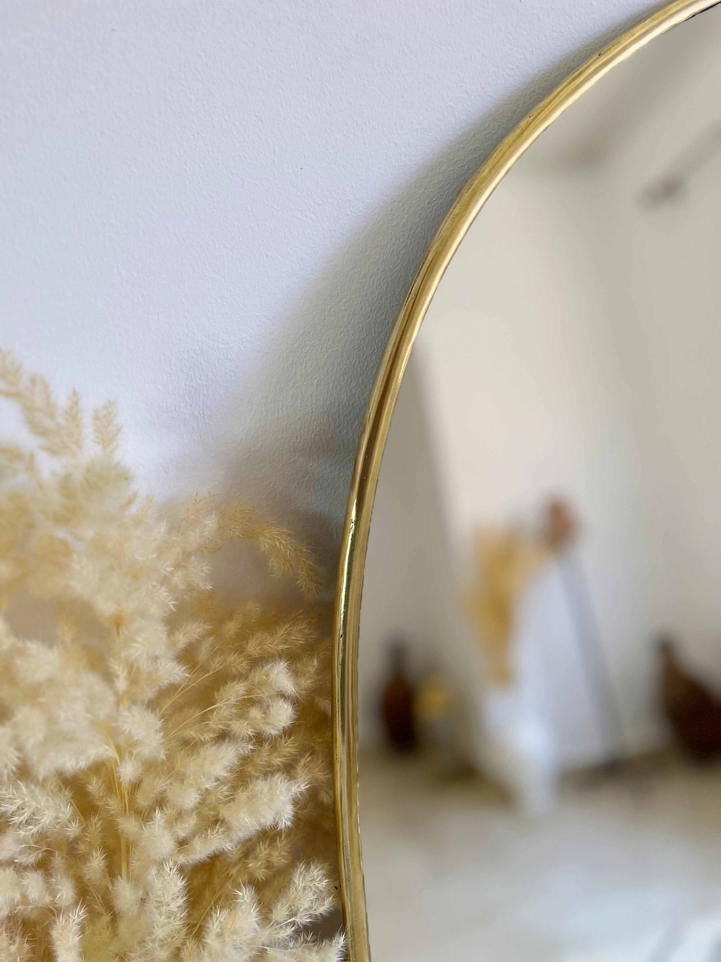 a mirror reflecting a woman in a white dress