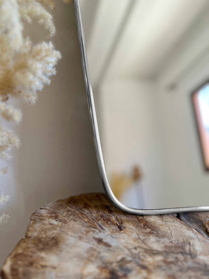 a mirror sitting on top of a wooden table