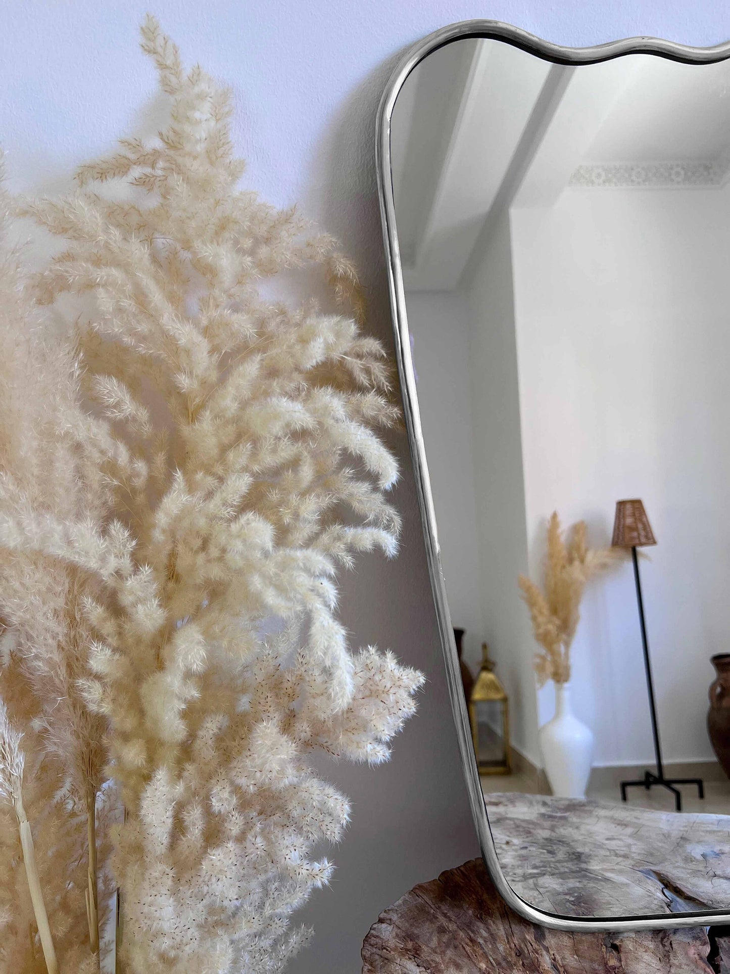 a mirror sitting on top of a table next to a plant