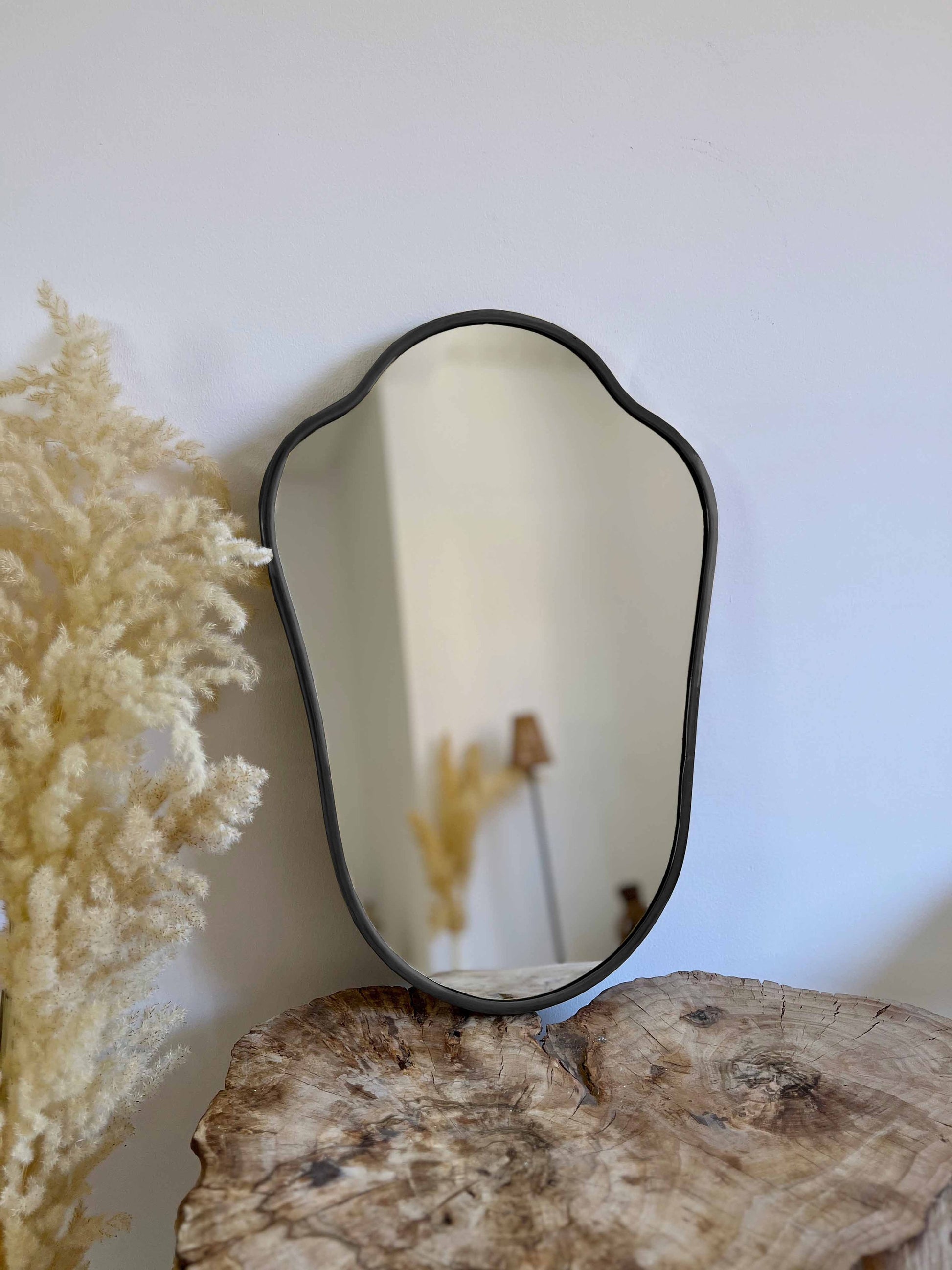 a mirror sitting on top of a tree stump