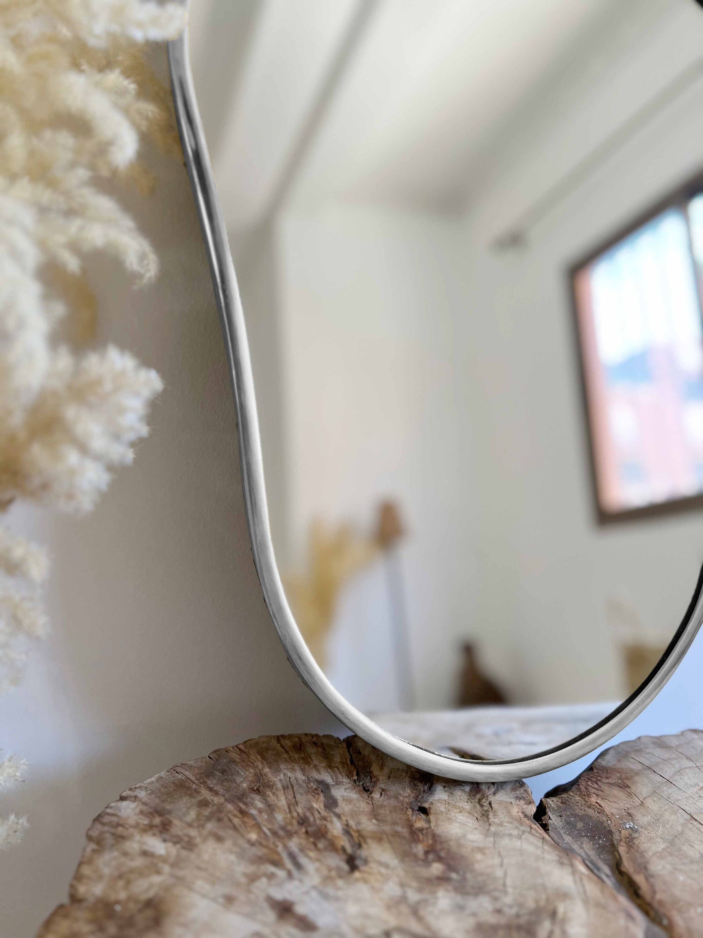 a mirror sitting on top of a piece of wood