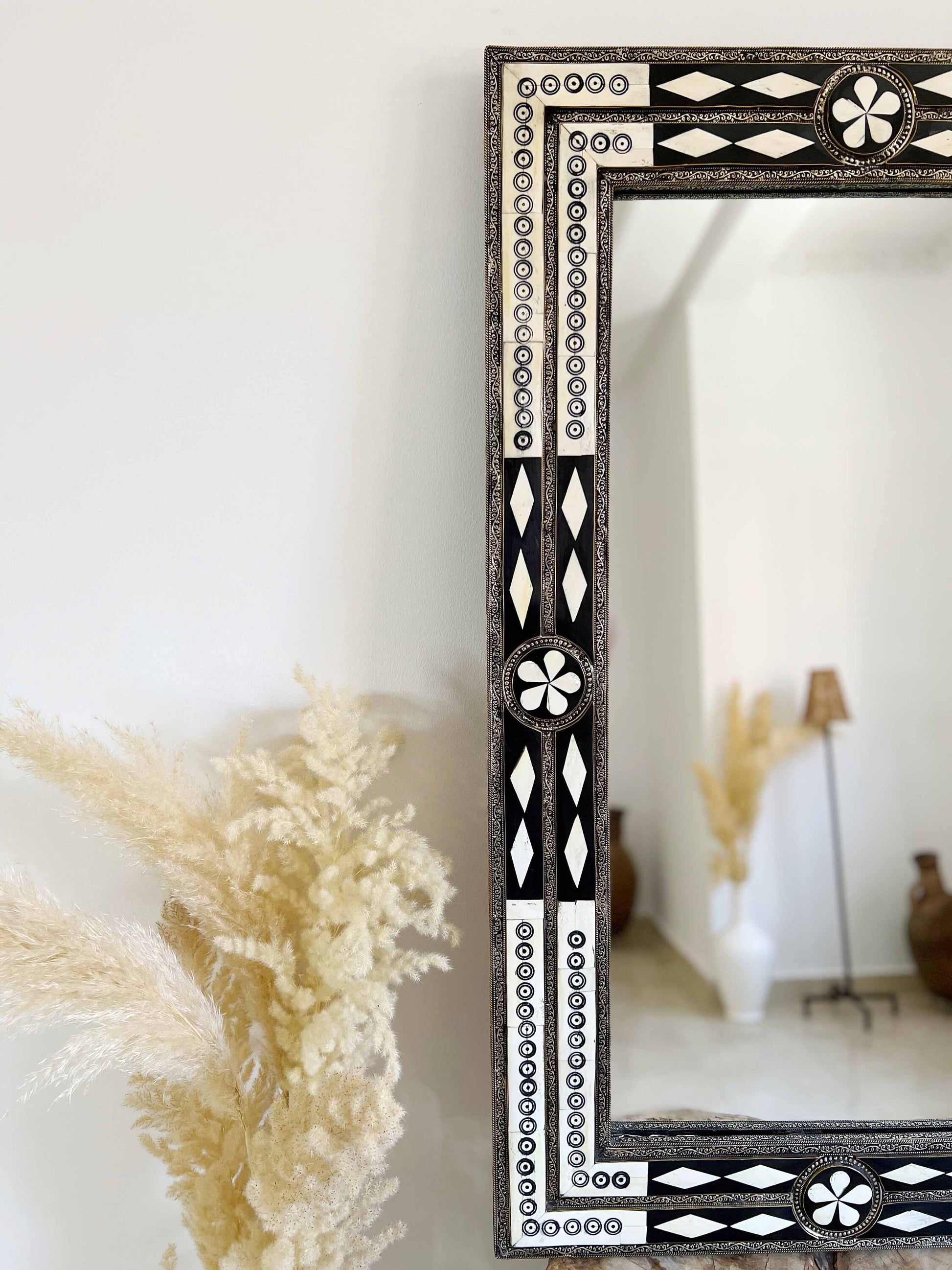a mirror sitting on top of a table next to a plant