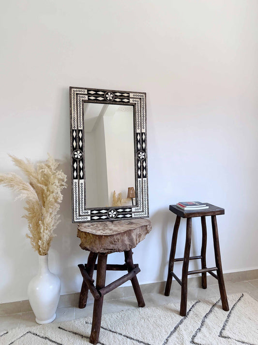 a mirror sitting on top of a wooden stool