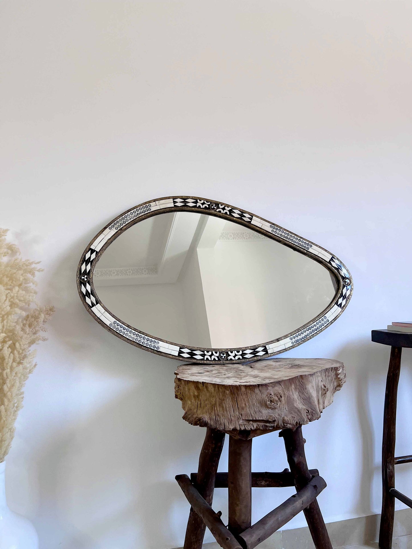 a mirror on a wall next to a stool