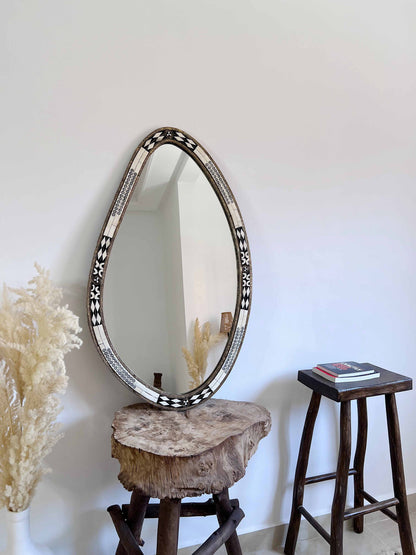 a mirror sitting on top of a wooden stool