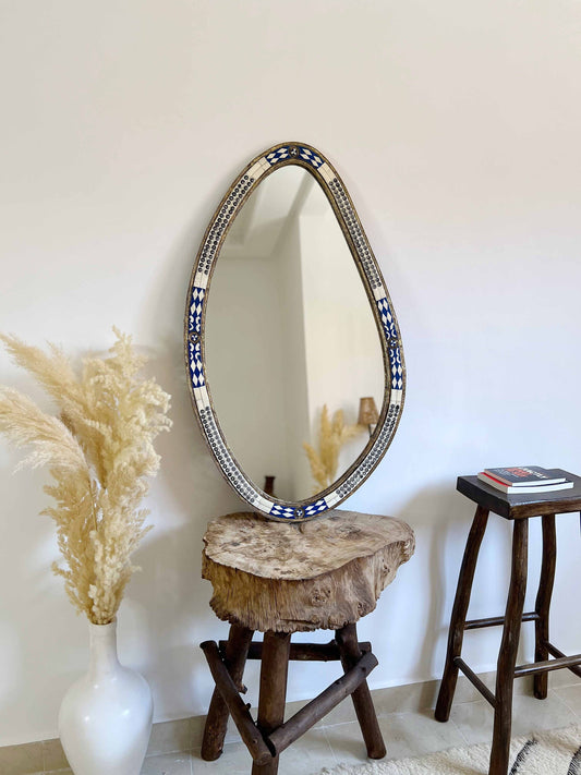 a mirror sitting on top of a wooden stool