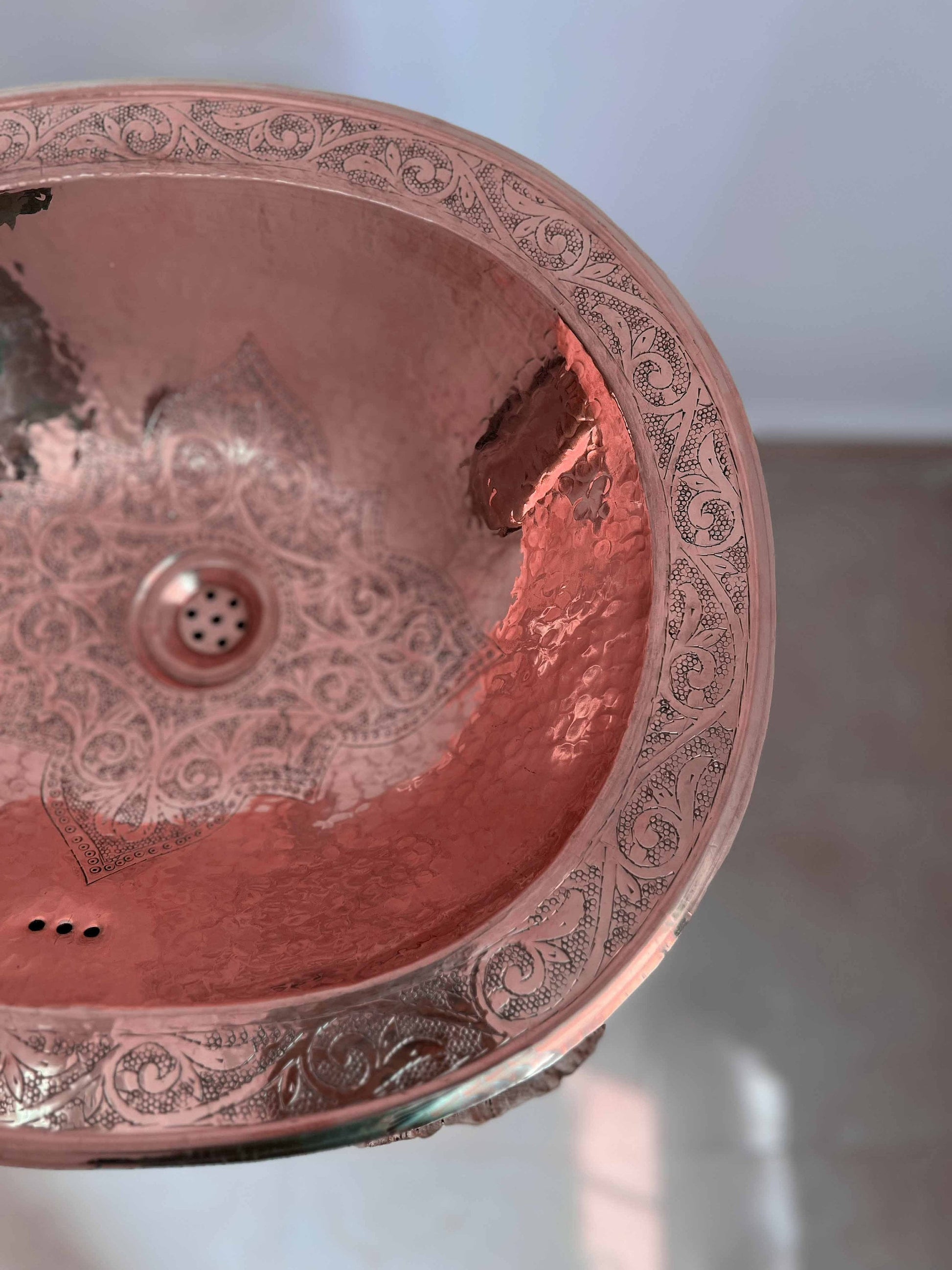 a pink sink with intricate designs on it