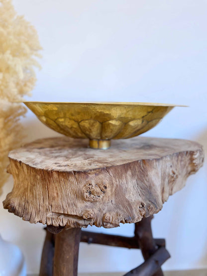 a wooden table with a gold bowl on top of it