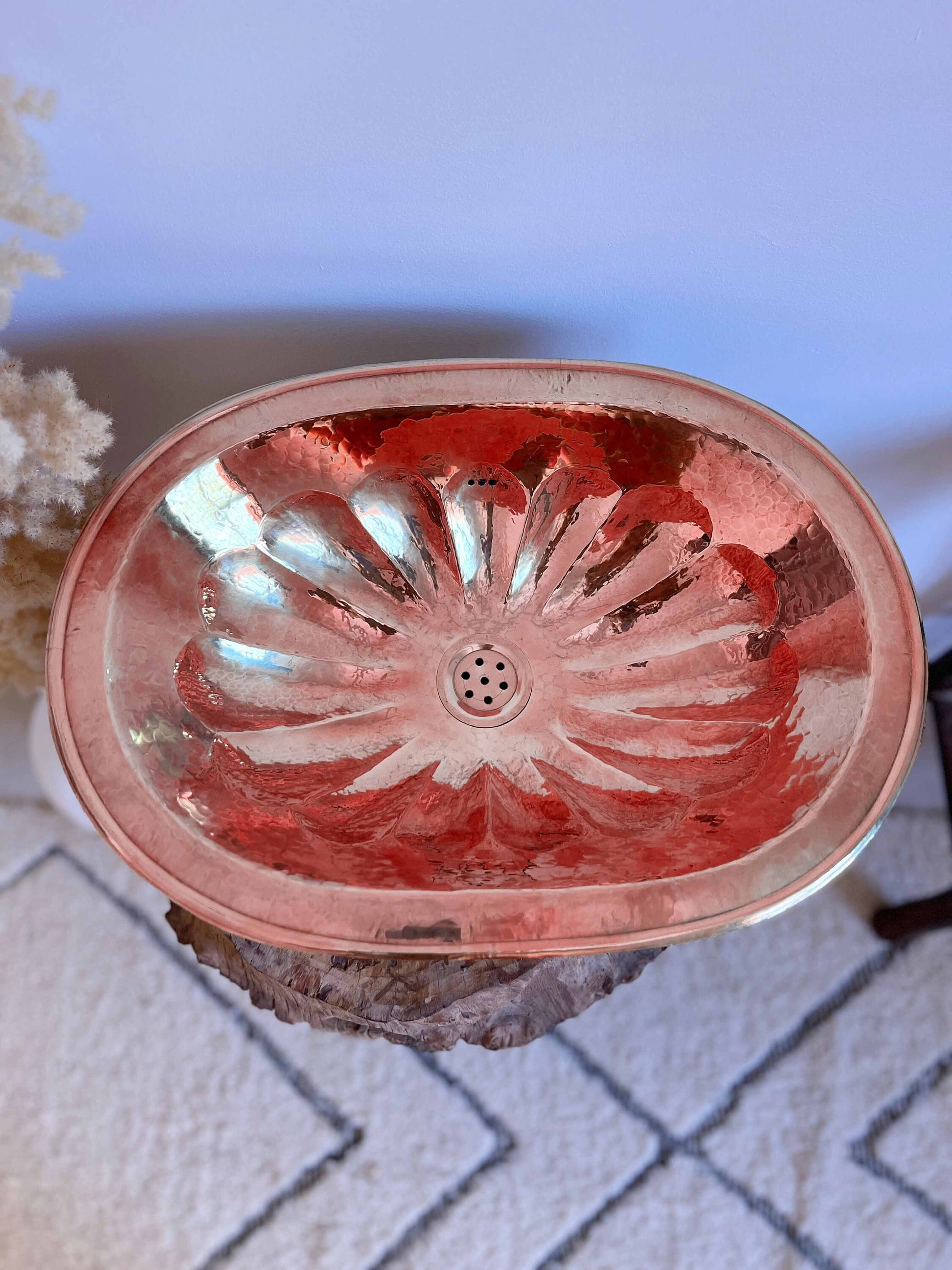 a pink bowl sitting on top of a rock