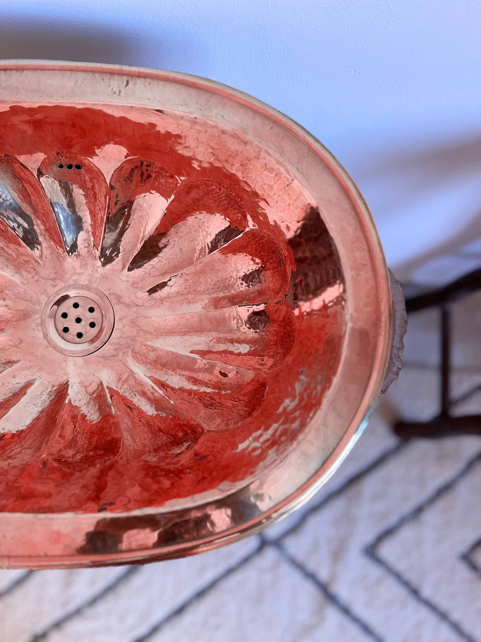 a metal sink with a flower design on it