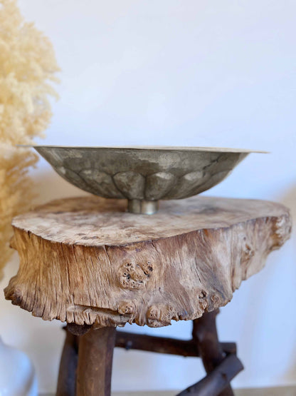 a wooden table with a metal bowl on top of it