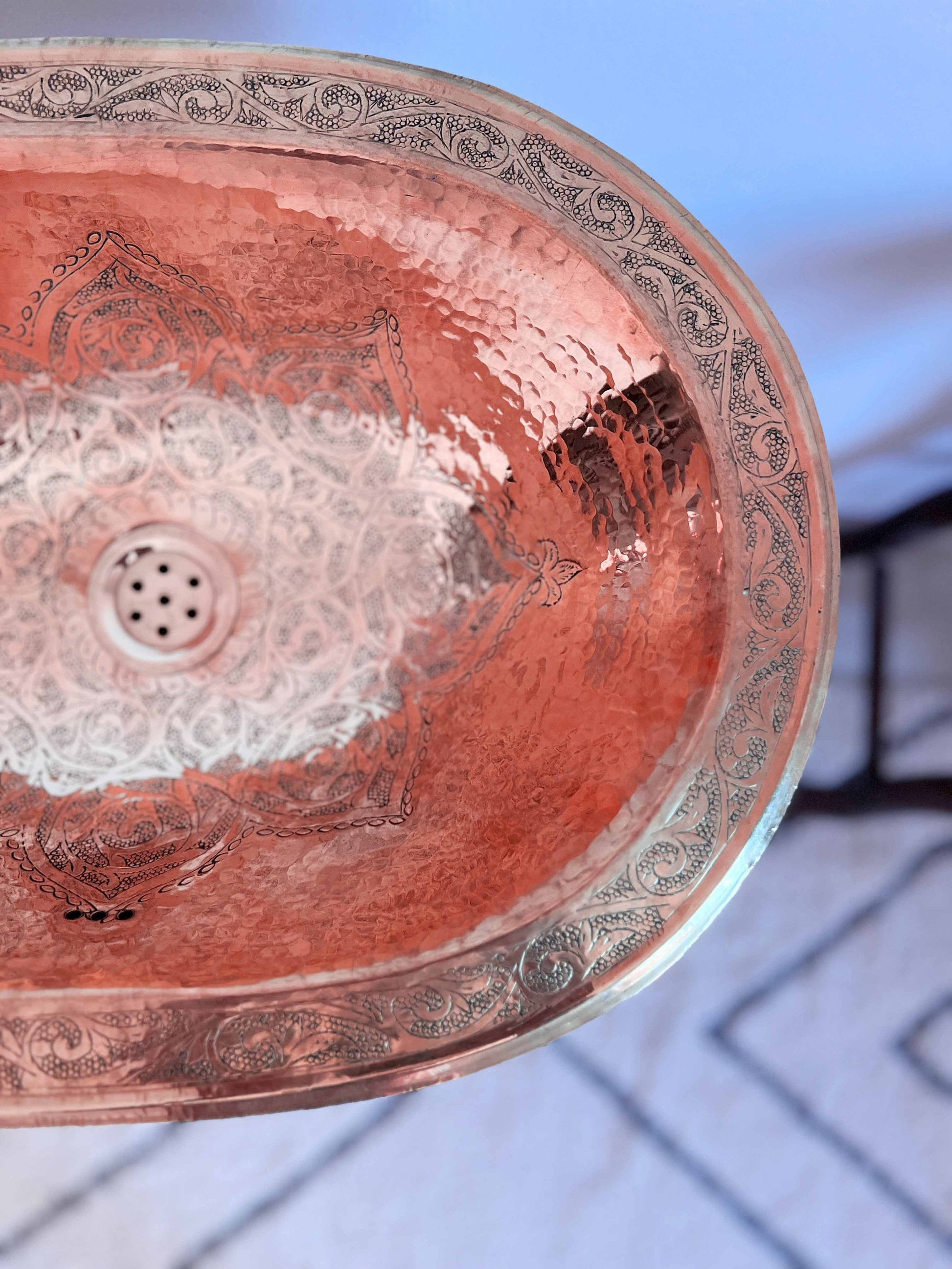 a copper sink with intricate designs on it