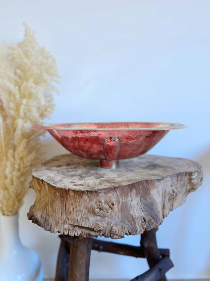 a red bowl sitting on top of a wooden table