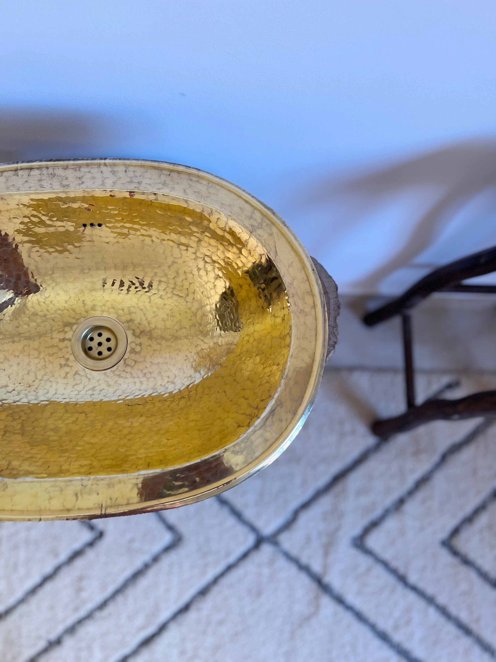 a gold sink sitting on top of a white rug