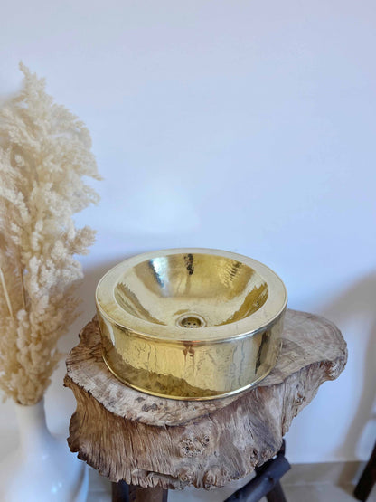 a metal bowl sitting on top of a wooden stump