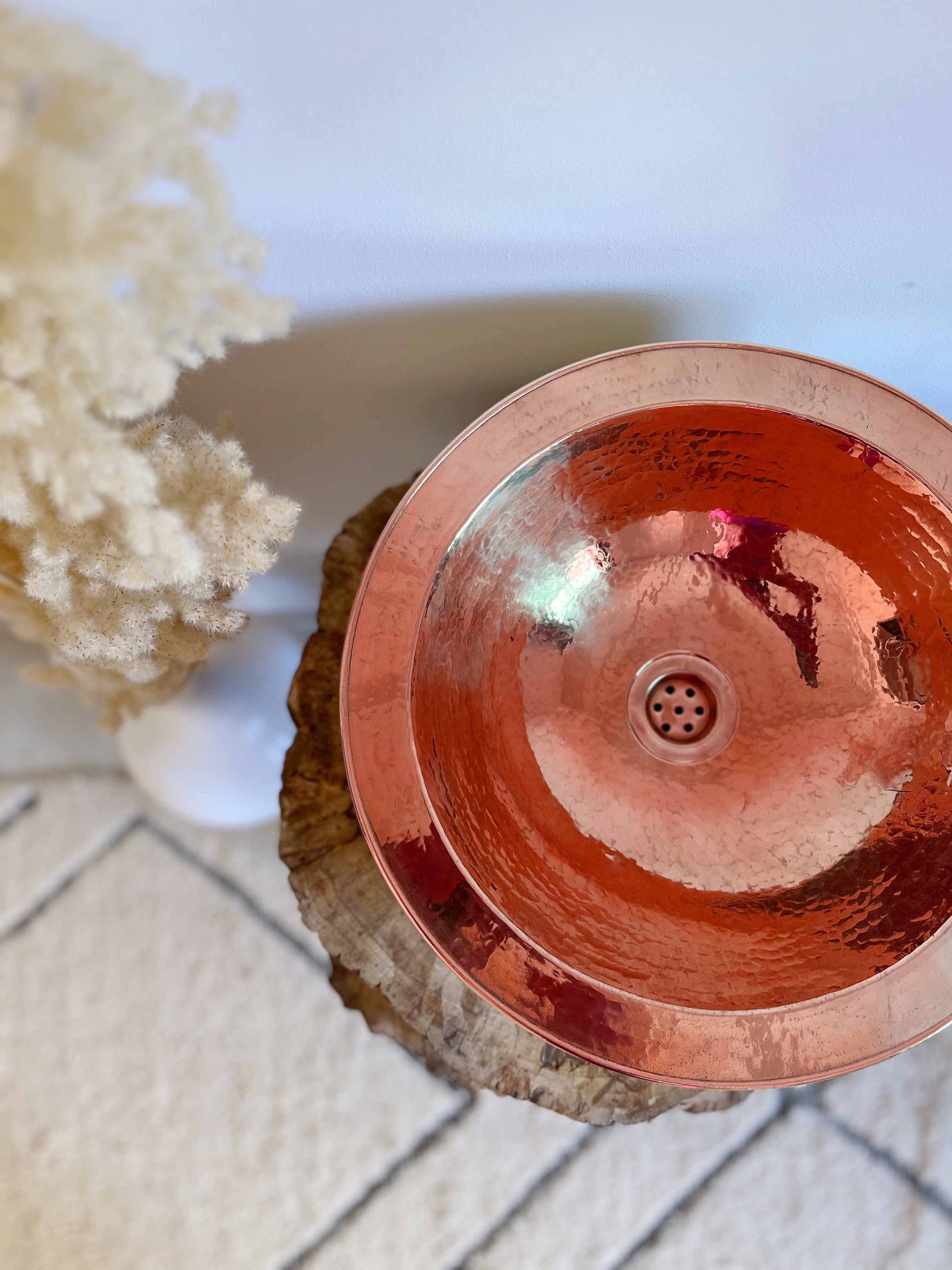 a metal bowl sitting on top of a wooden stump