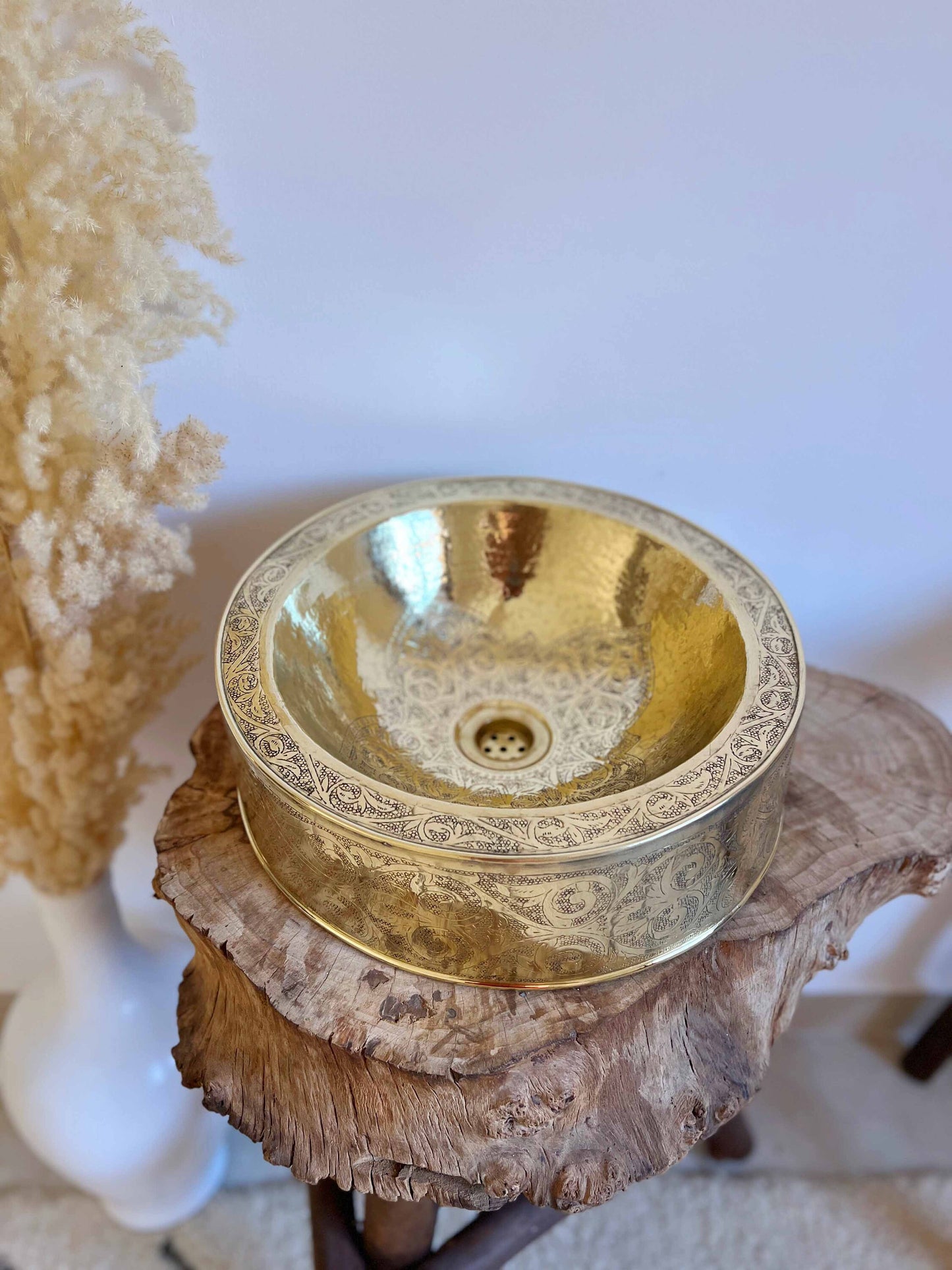 a gold bowl sitting on top of a tree stump