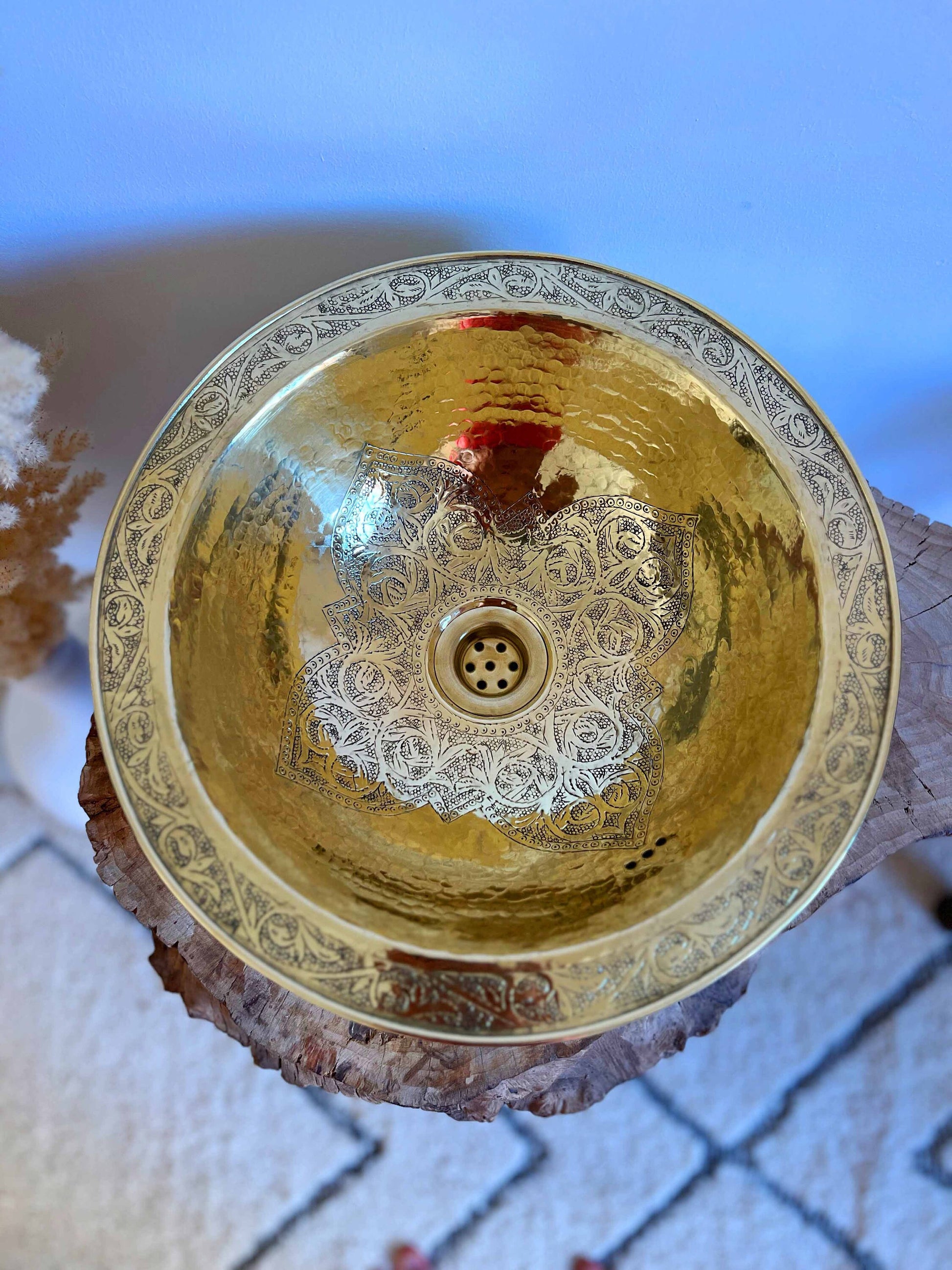 a golden bowl sitting on top of a piece of wood