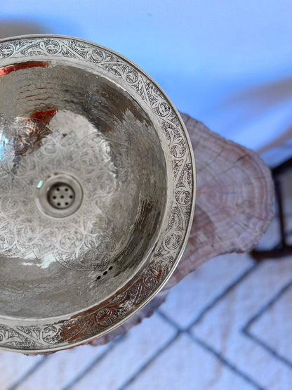 a person holding a metal bowl in their hand