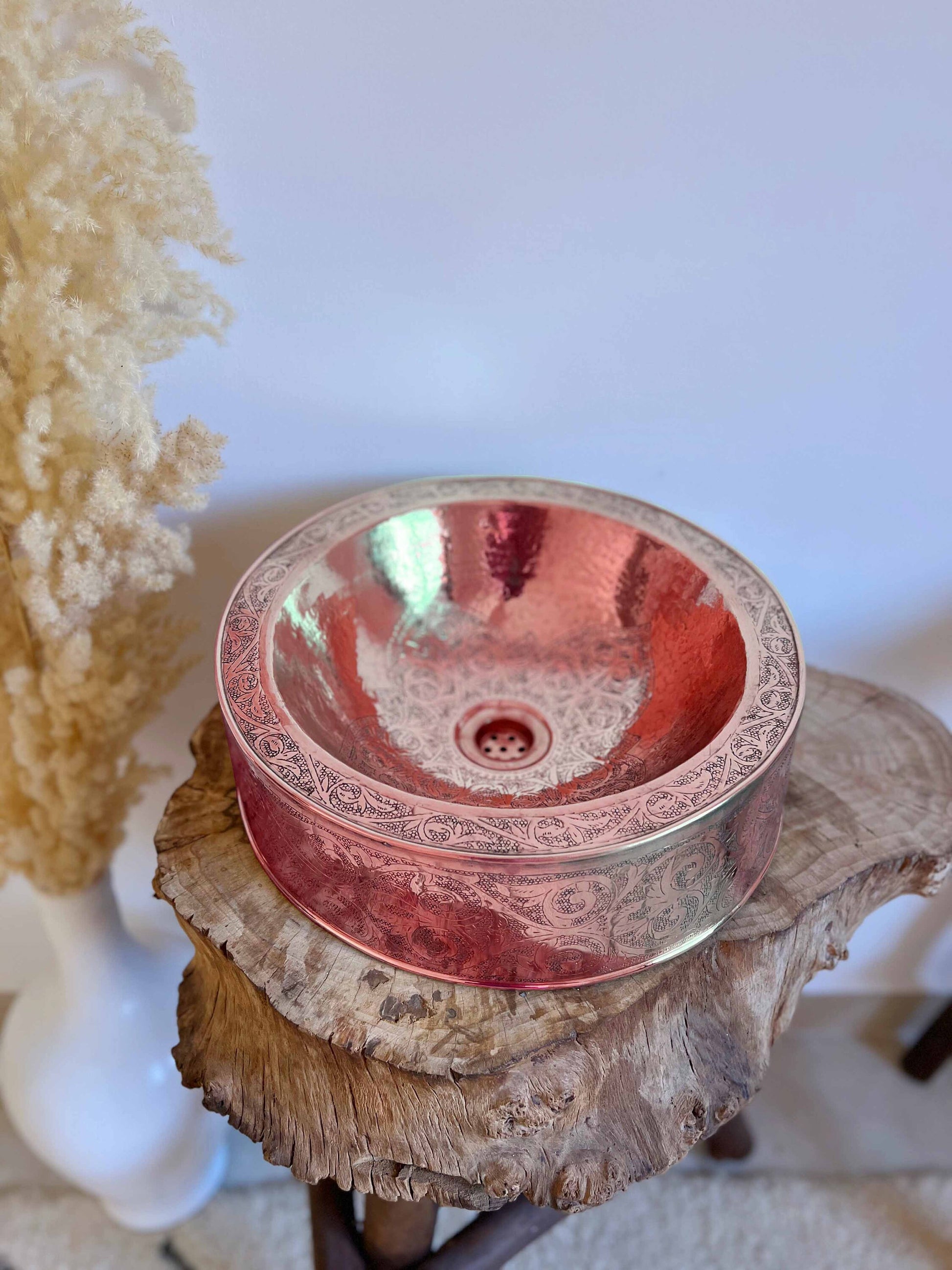 a glass bowl sitting on top of a tree stump