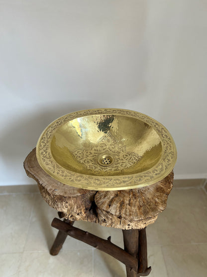 a gold sink sitting on top of a tree stump