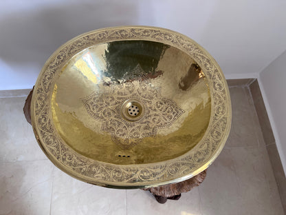 a gold sink in a bathroom with a marble floor