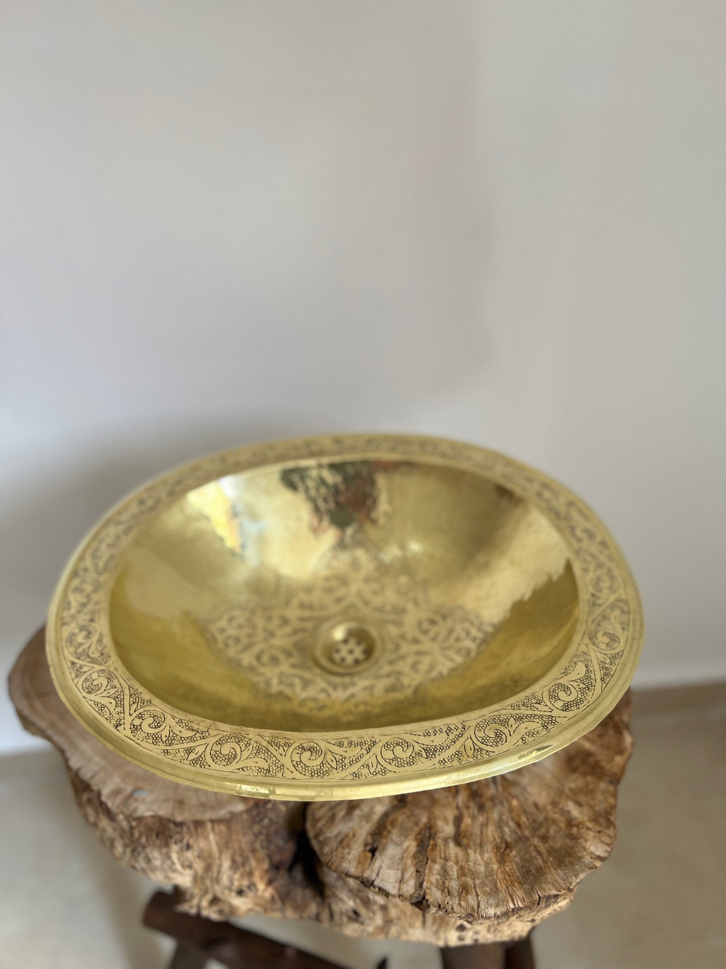 a gold sink sitting on top of a wooden stand