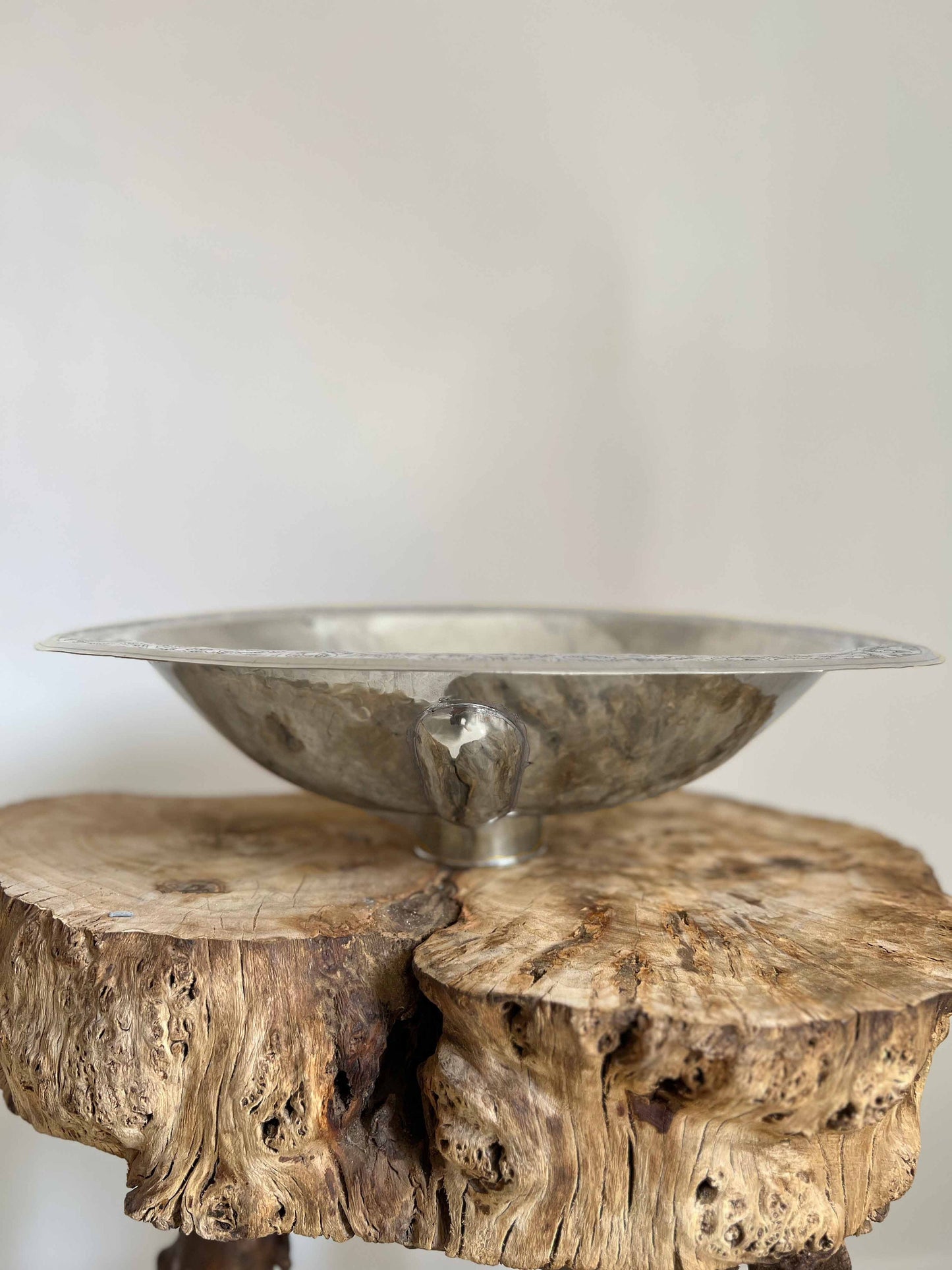 a wooden table with a metal bowl on top of it