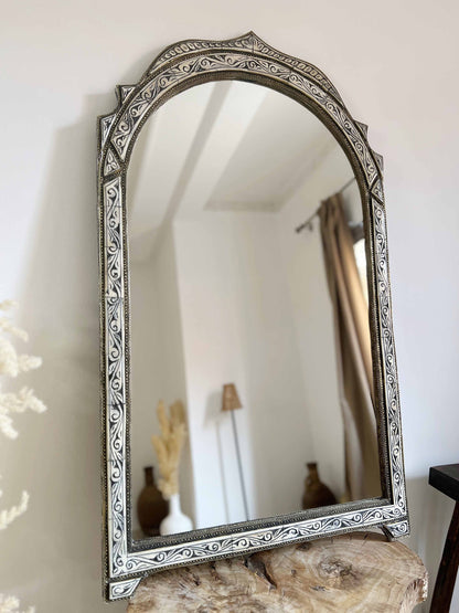 a mirror sitting on top of a wooden table