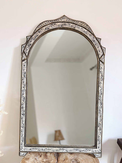 a mirror sitting on top of a wooden table