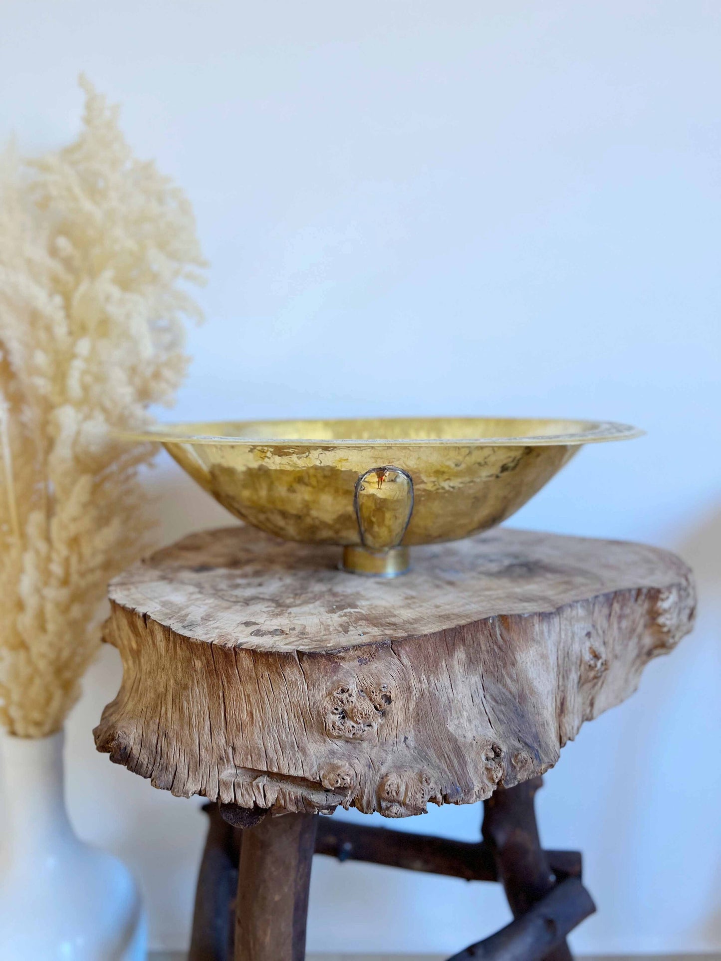 a wooden table with a gold bowl on top of it