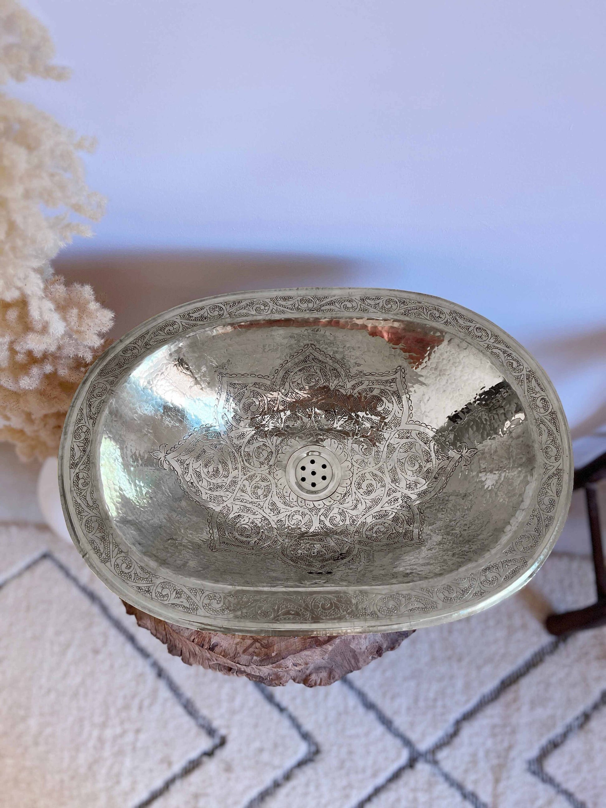 a silver sink sitting on top of a white rug