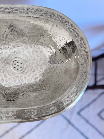 a metal sink hanging from a ceiling in a bathroom