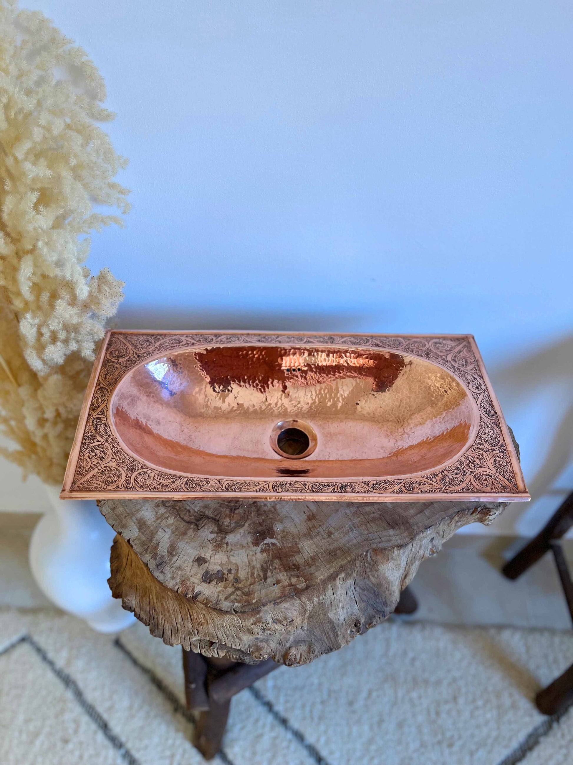 a bathroom sink sitting on top of a tree stump