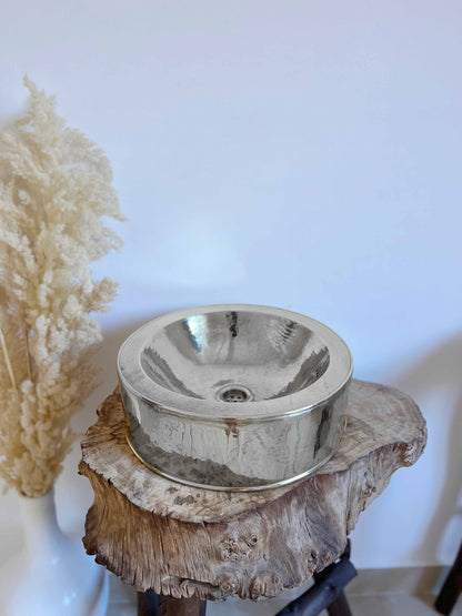 a metal bowl sitting on top of a tree stump