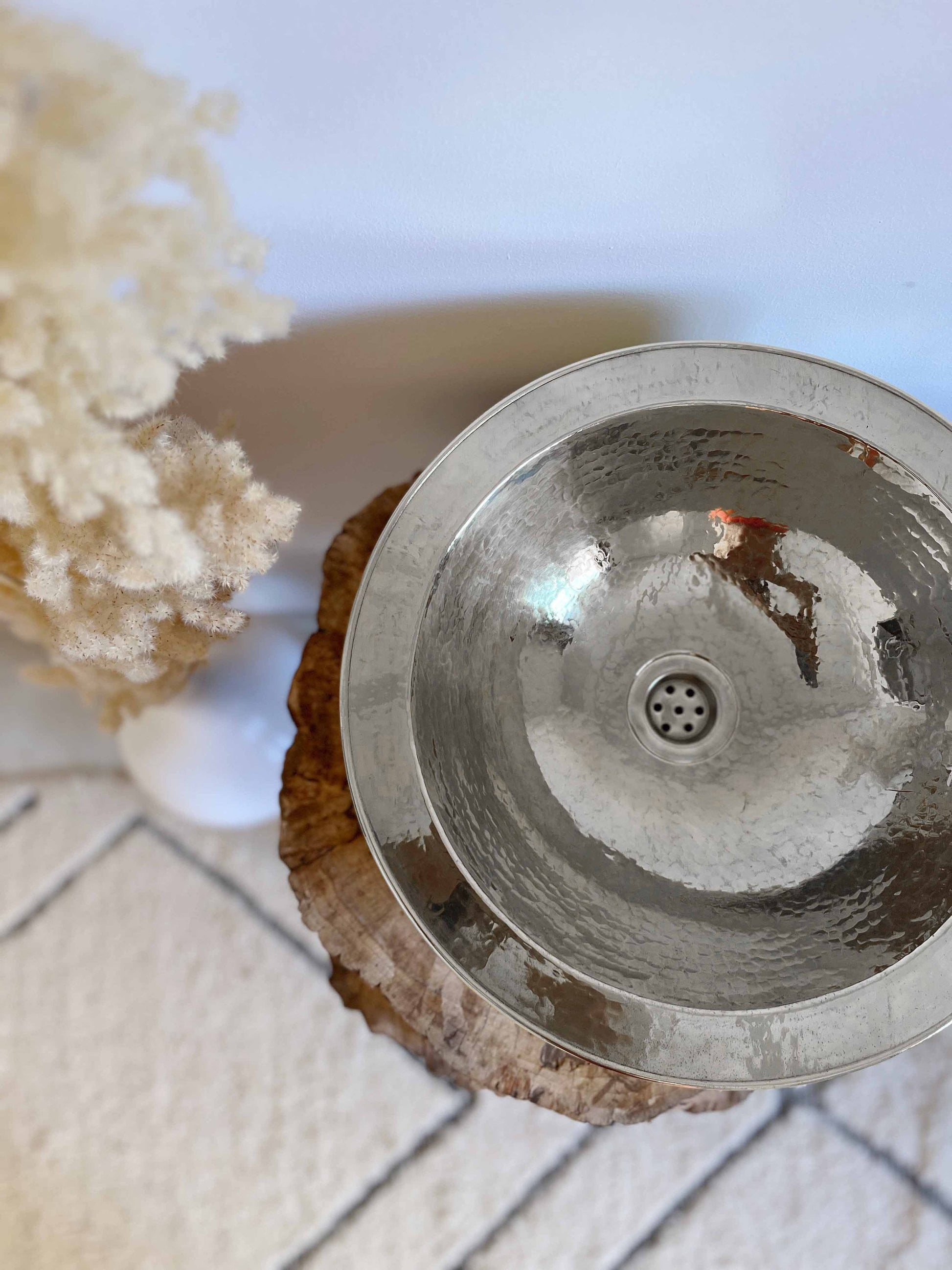 a metal bowl sitting on top of a piece of wood