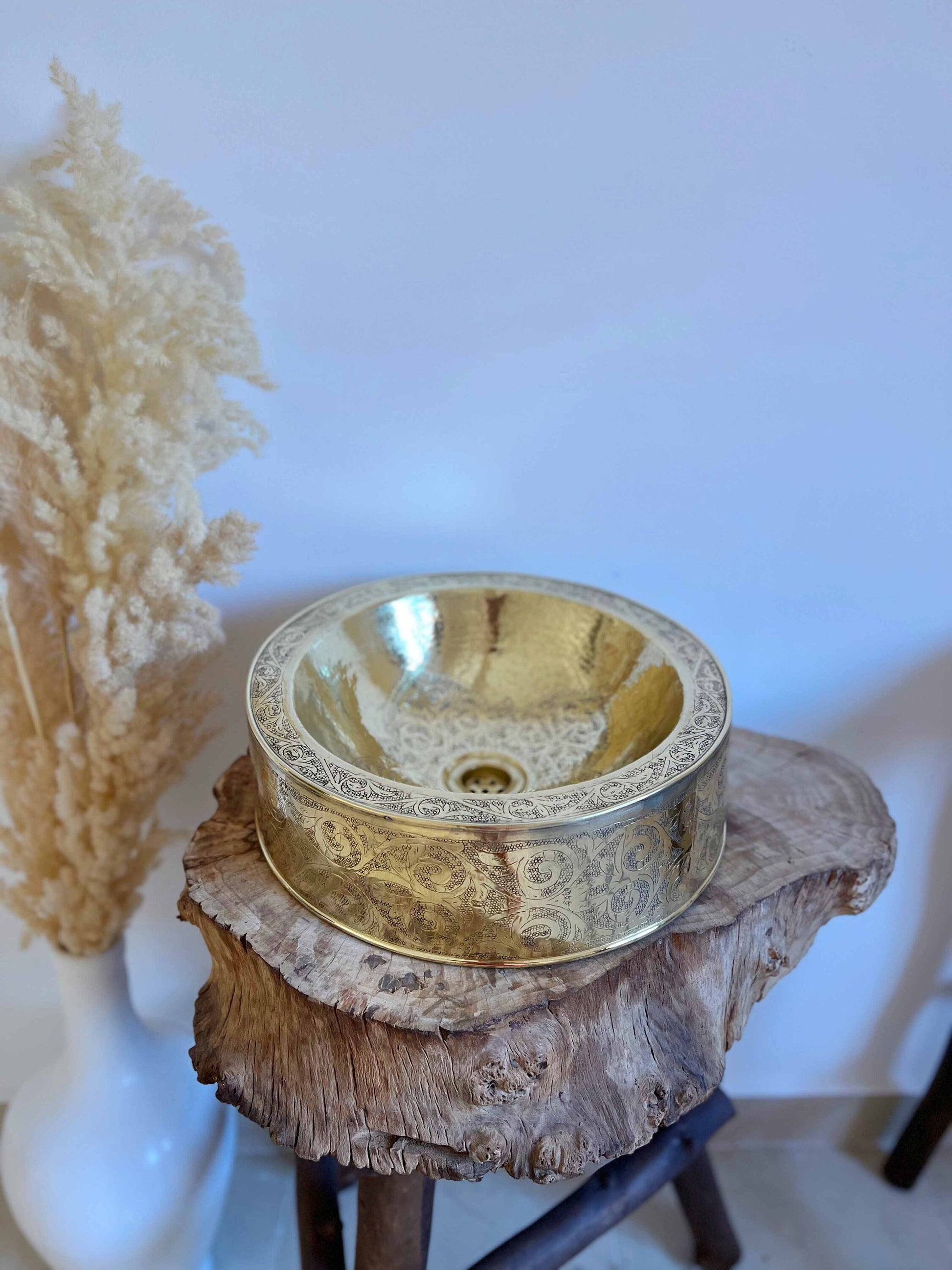 a gold bowl sitting on top of a tree stump