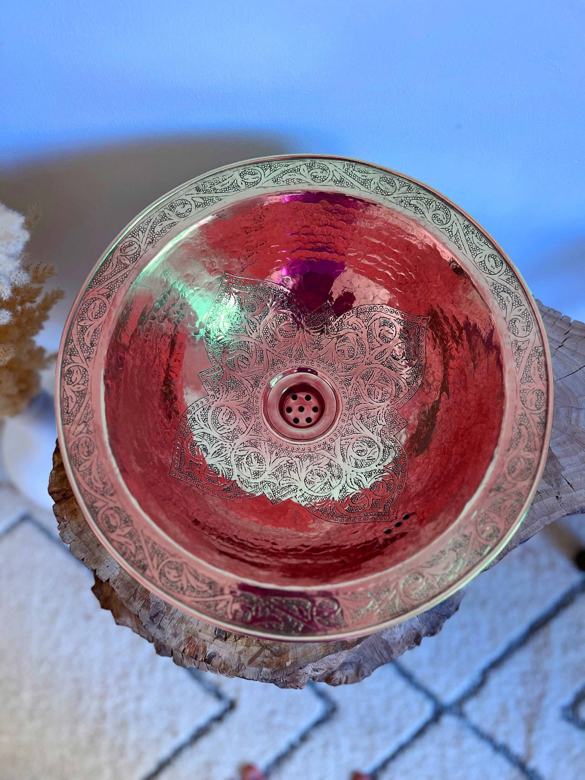 a red glass bowl sitting on top of a table