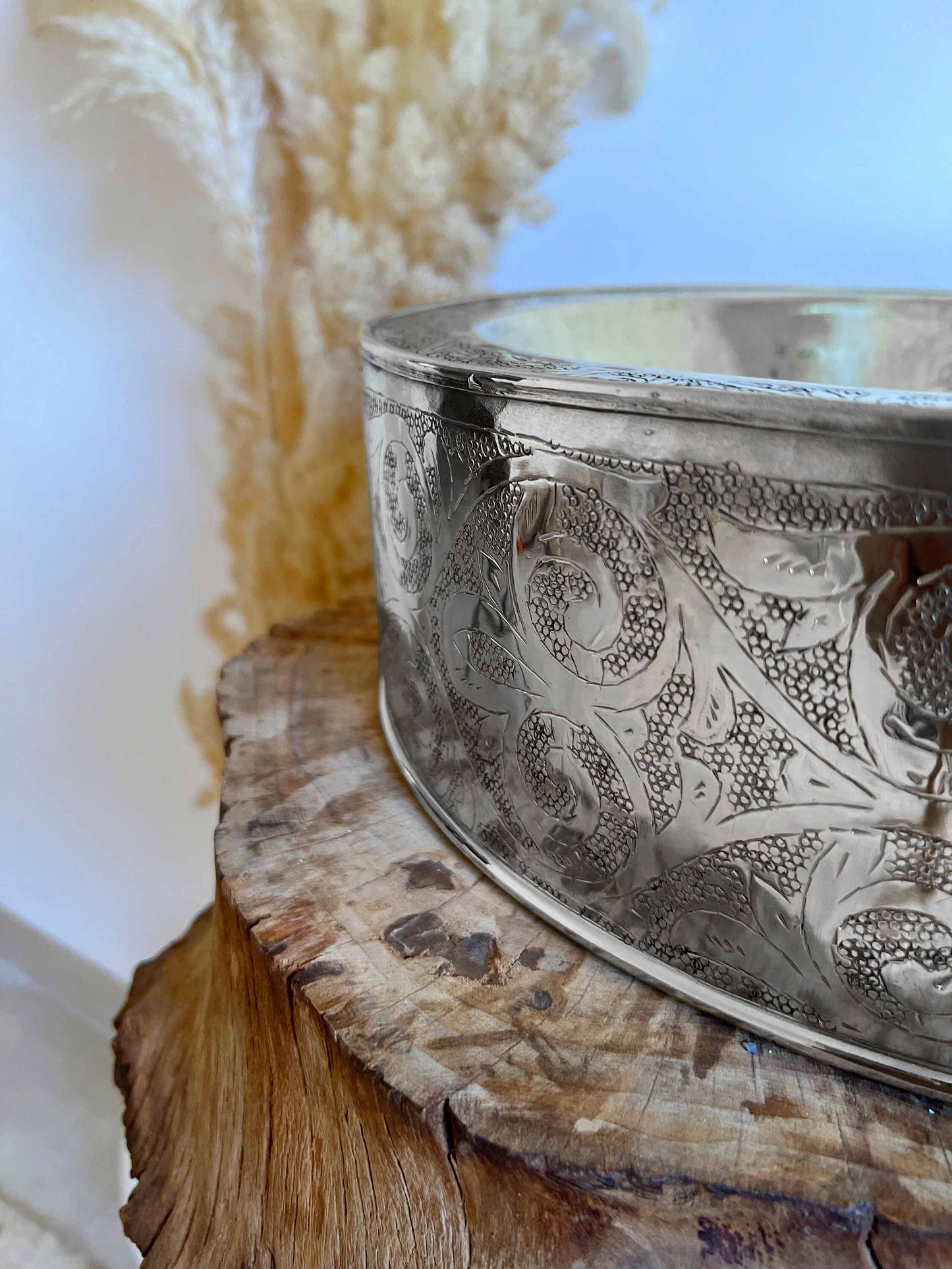 a metal bowl sitting on top of a wooden table