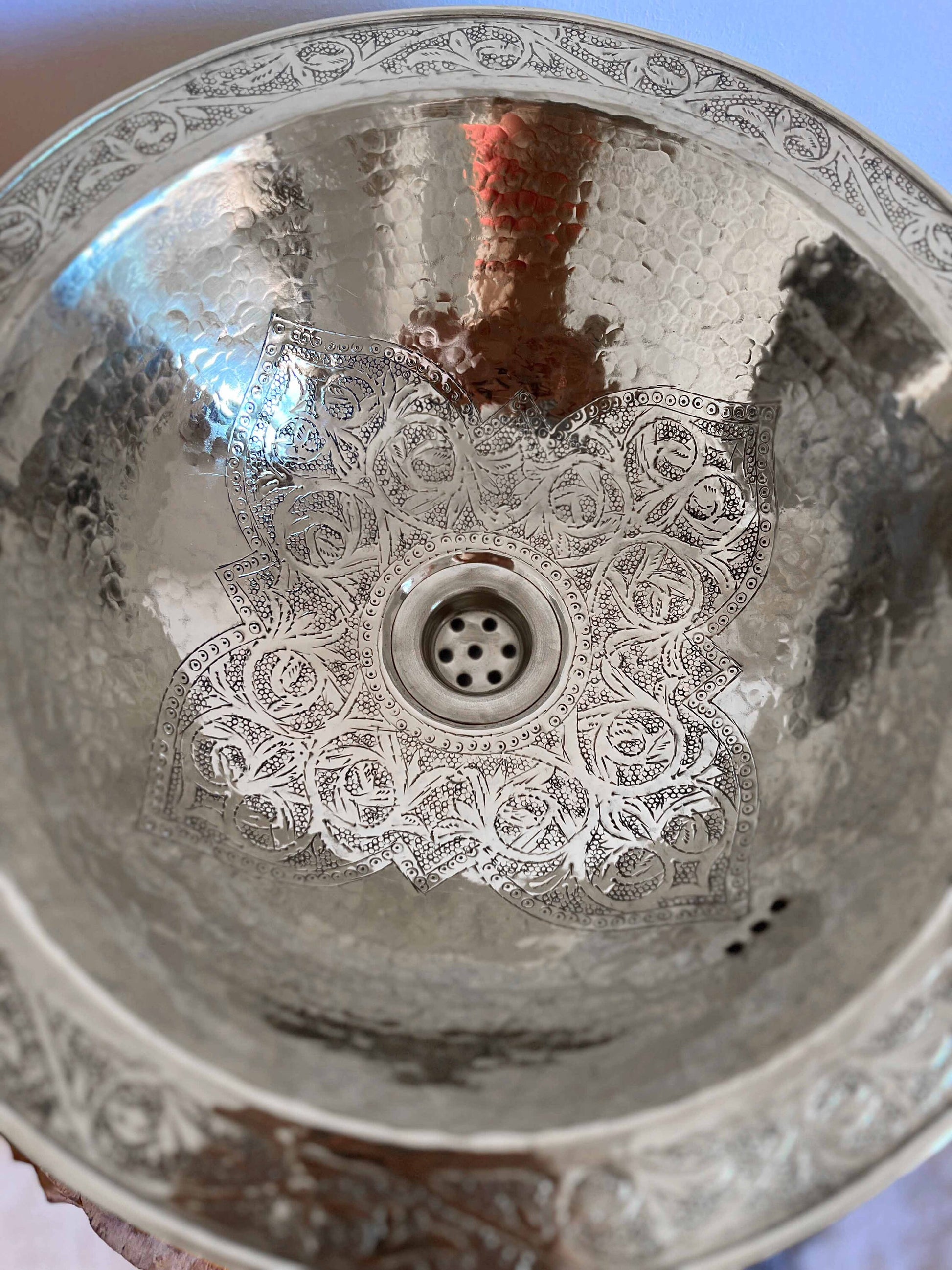 a silver sink sitting on top of a table