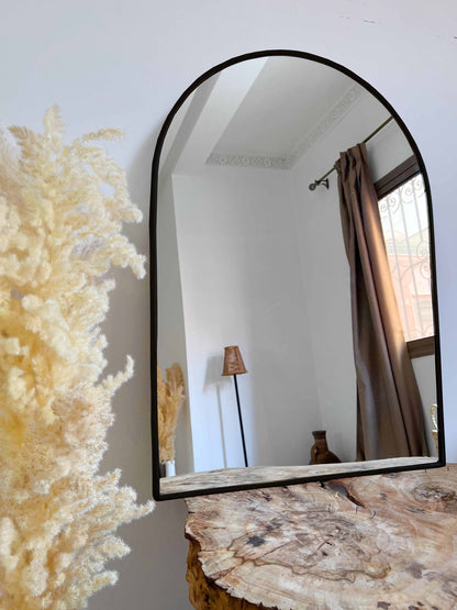 a mirror sitting on top of a wooden table