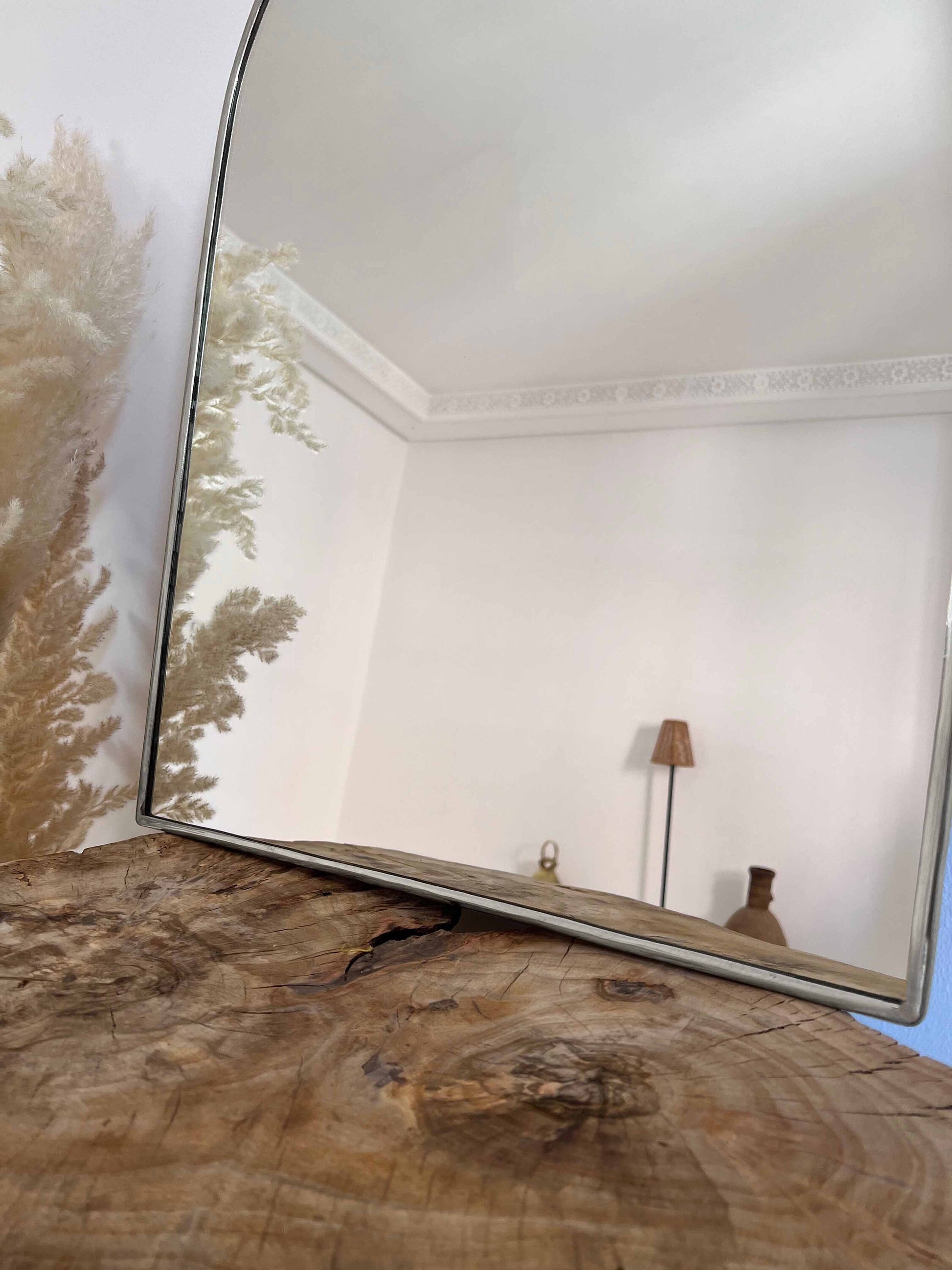 a mirror sitting on top of a wooden table