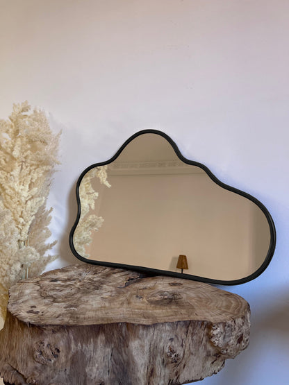 a mirror sitting on top of a wooden table