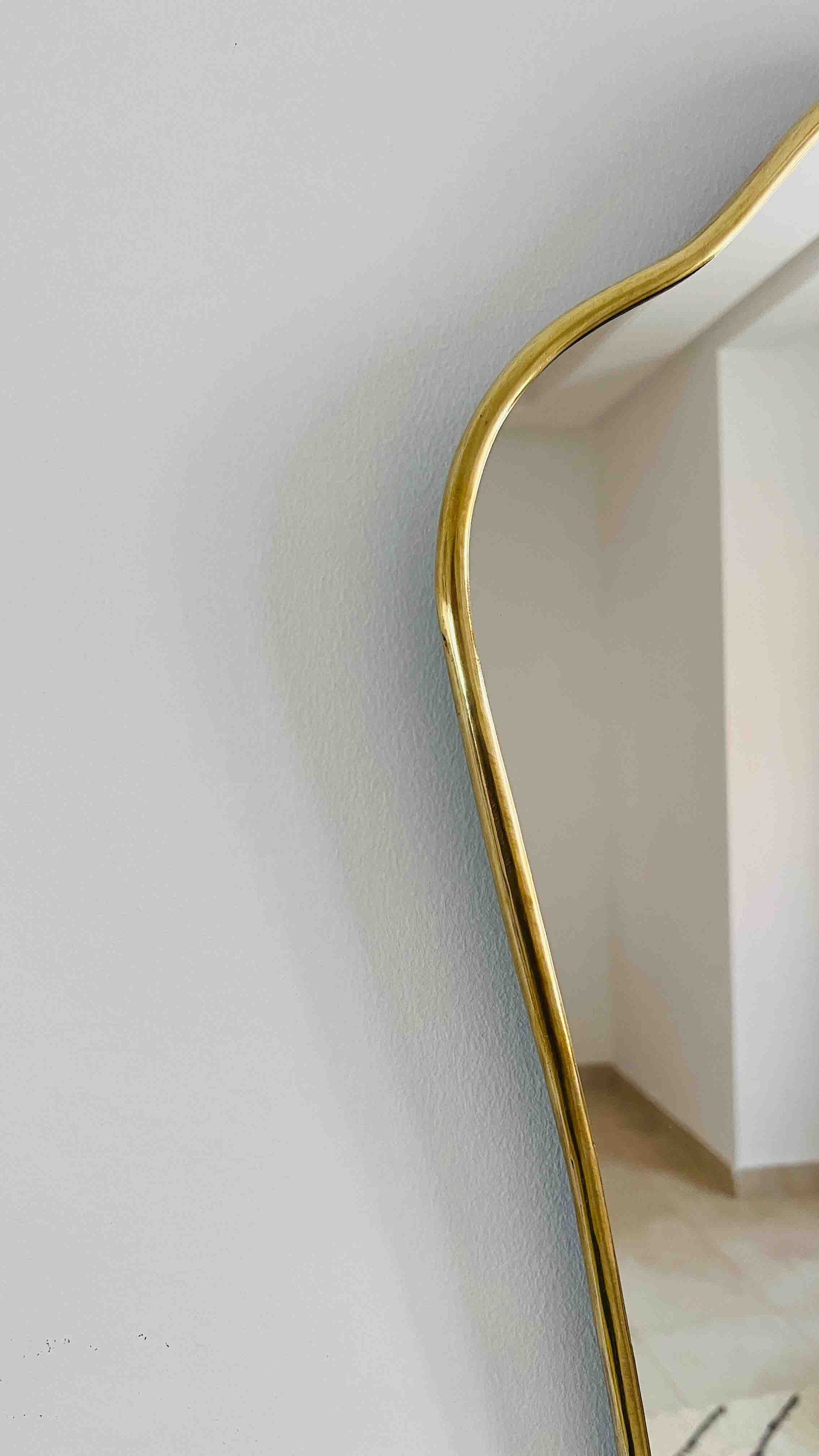 a gold framed mirror on a white wall