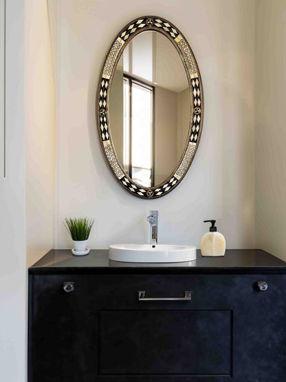 a bathroom with a round mirror above a sink