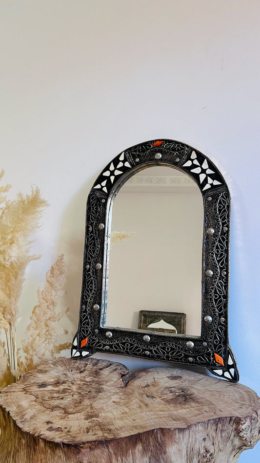 a mirror sitting on top of a wooden table